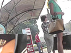 Blonde waits for a bus in the upskirt outdoor scene