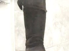 Amateur in high boots sits pissing in public toilet